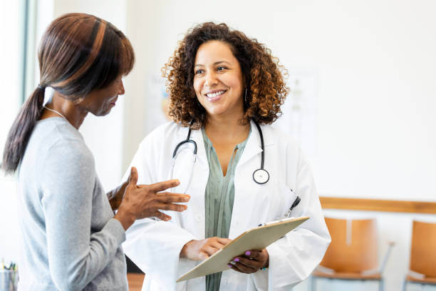 Female doctor and patient talking; healthcare, medicine, consultation.